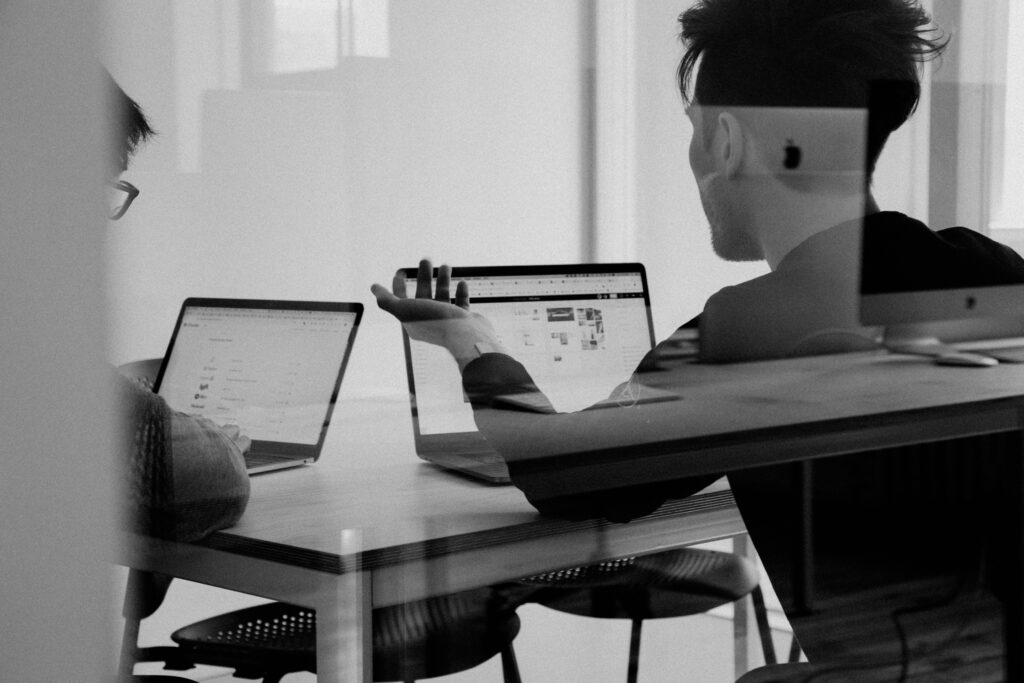 Image of two people working on their laptops