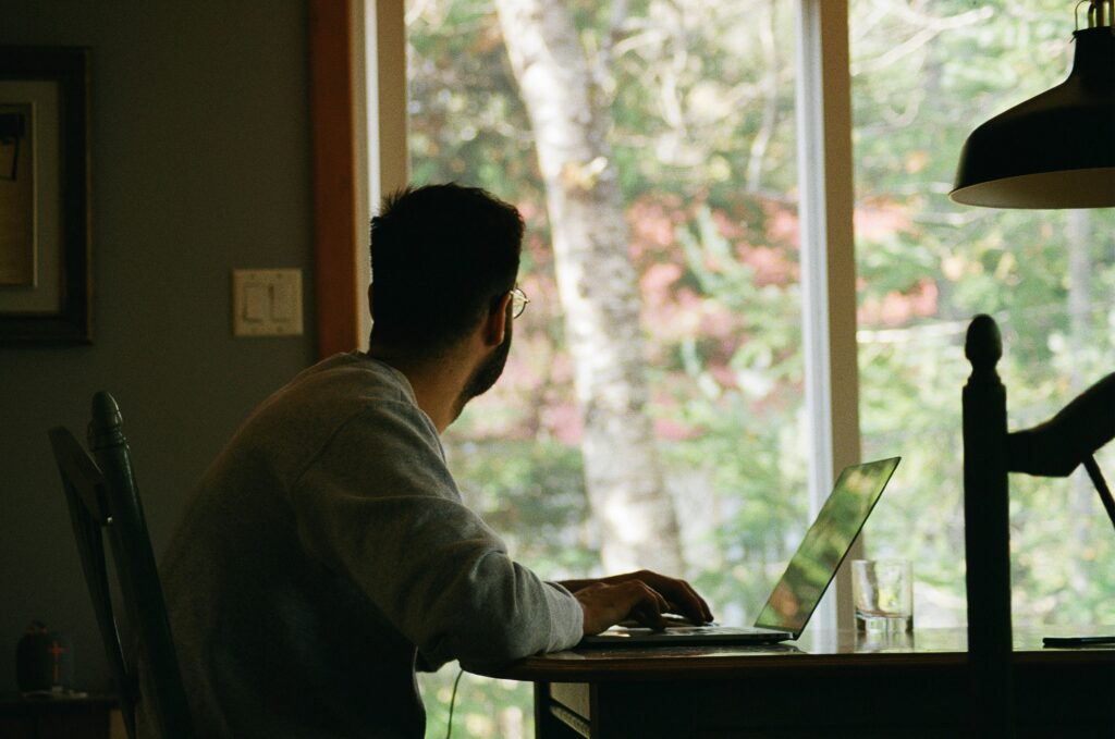 Image showing a man working on his desk as he stares towards a window outside